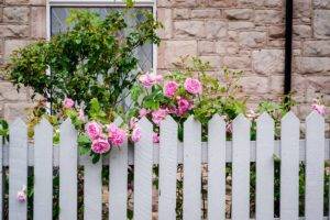 Picket fence in front of a old brick house